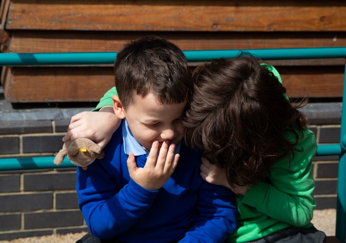 Pupils sitting together in playground