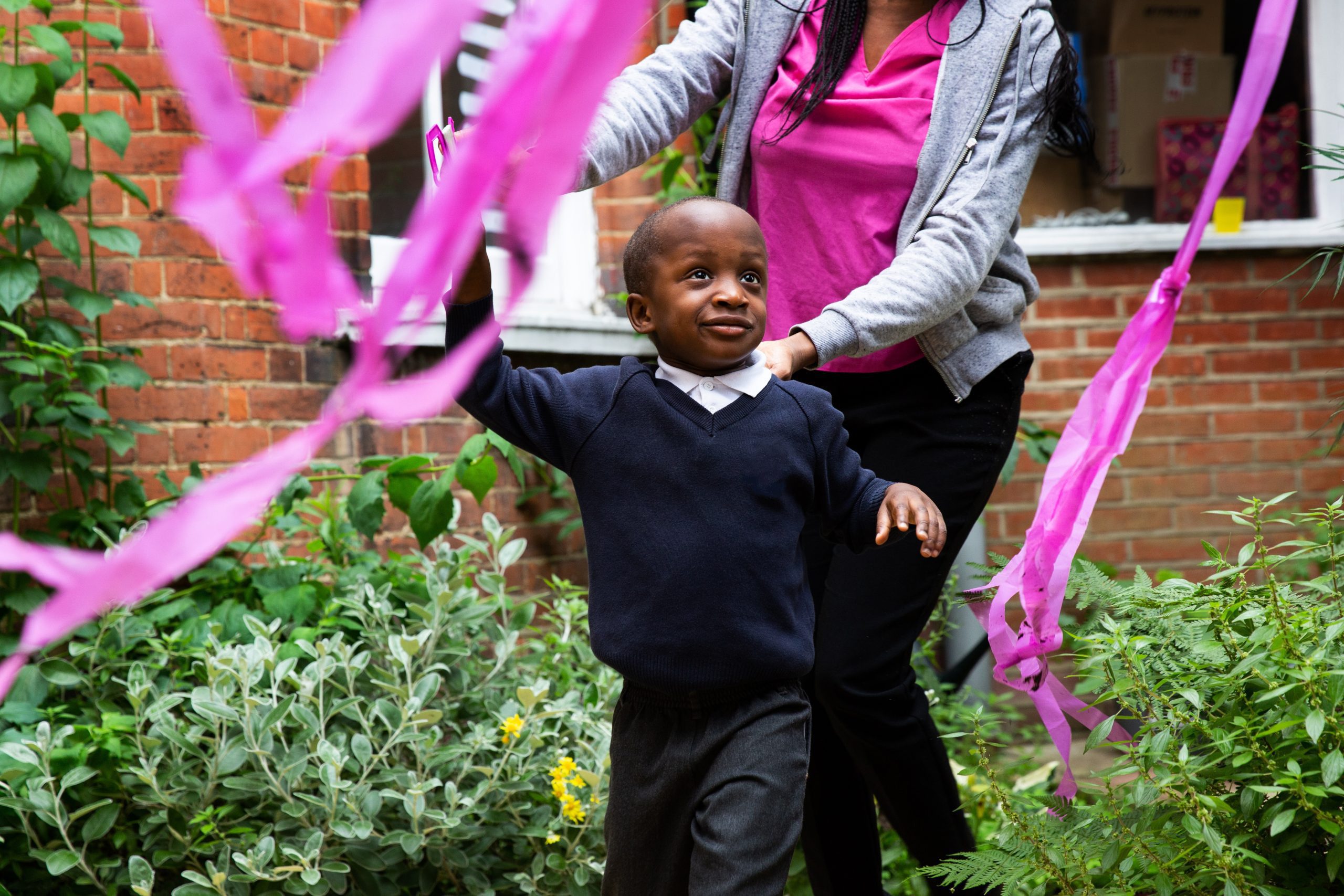 Child playing outside with ribbon